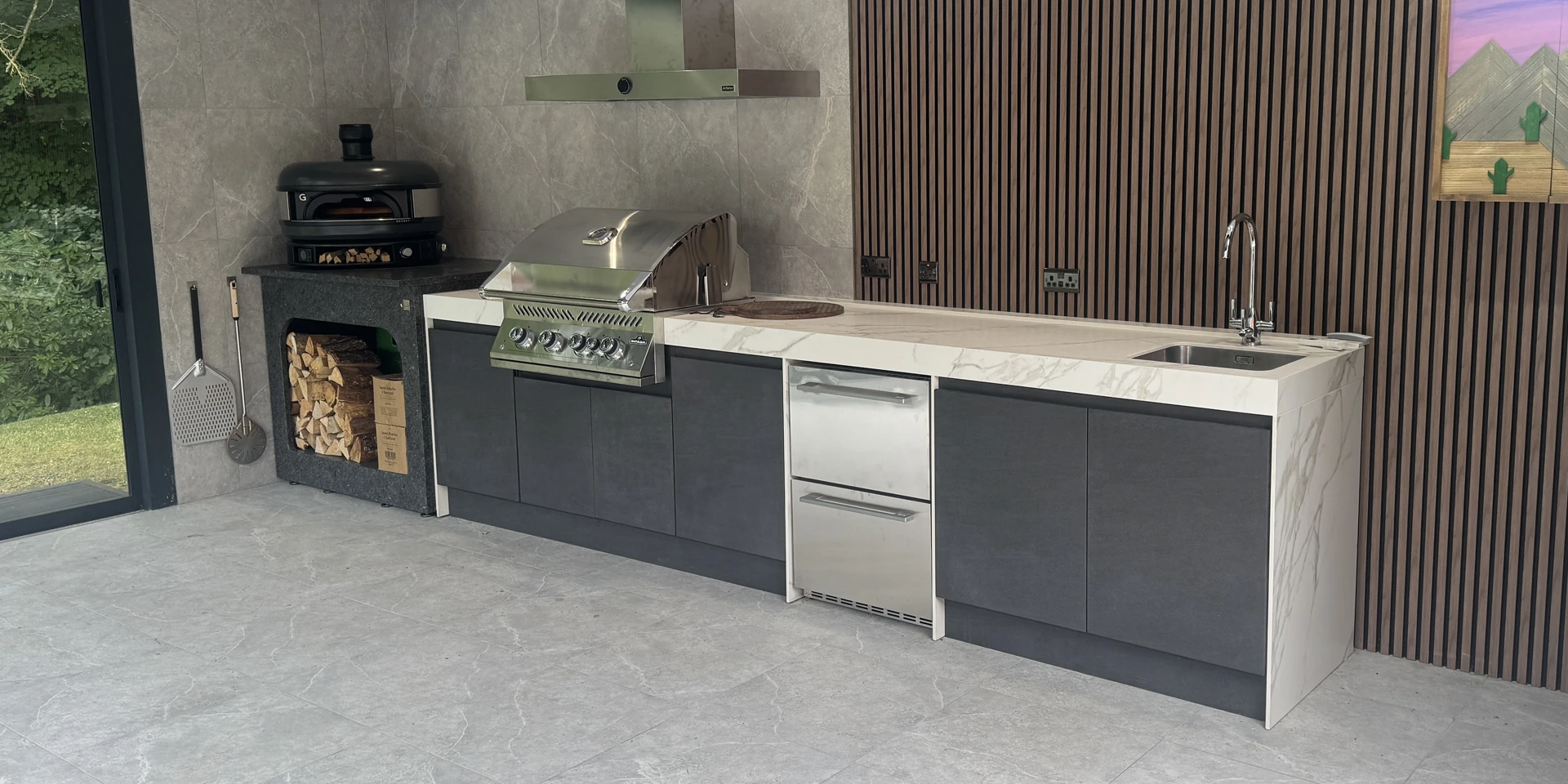 an Outdoor kitchen in basalto nero and calacatta royal.